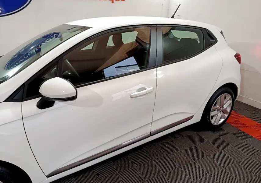 Profil côté gauche d'une Renault Clio Business Blue dCi 85 blanche, avec jantes alliage et poignées de porte assorties.