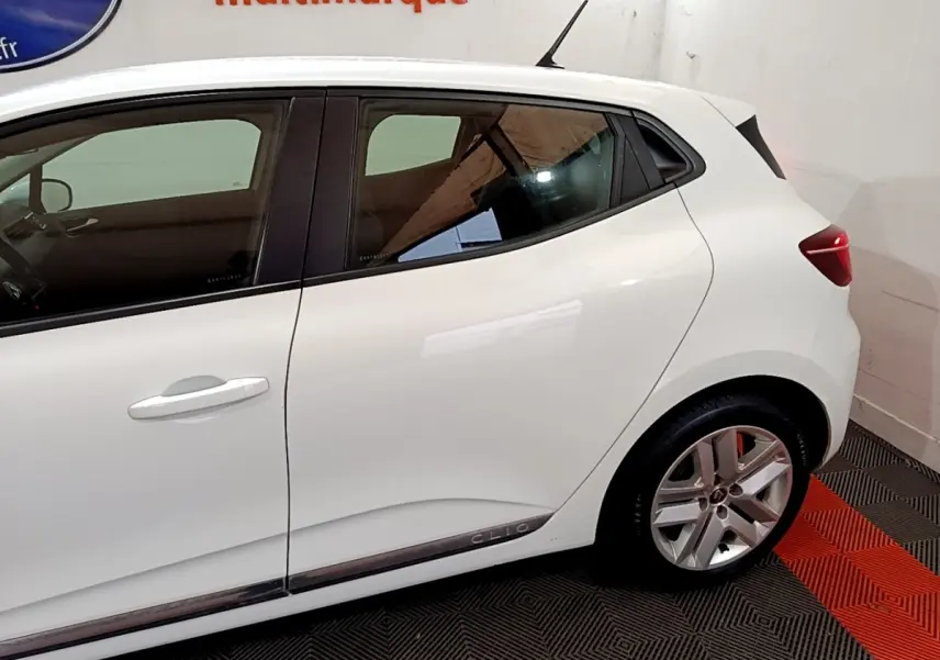 Profil côté gauche de la Renault Clio blanche 2020, mettant en valeur la ligne épurée et les jantes alliage.