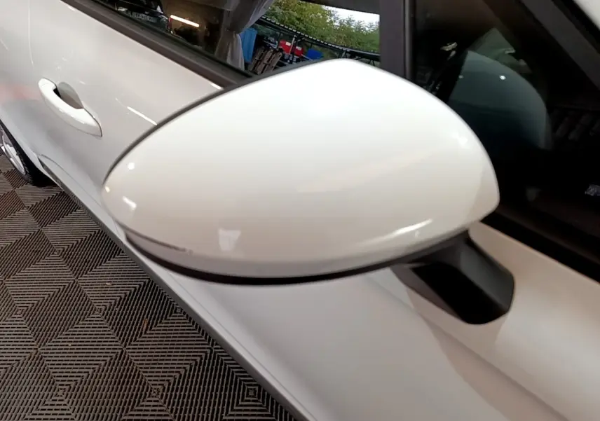 Rétroviseur blanc en gros plan côté gauche d'une Renault Clio Business Blue dCi 85 blanche, vue intérieure.