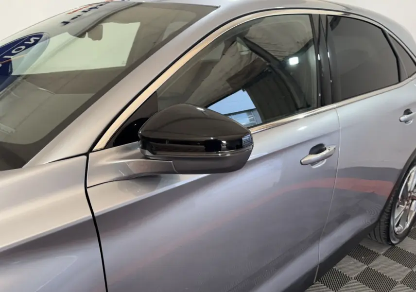 Vue latérale droite du DS7 Crossback gris foncé avec rétroviseur noir brillant et vitres teintées.