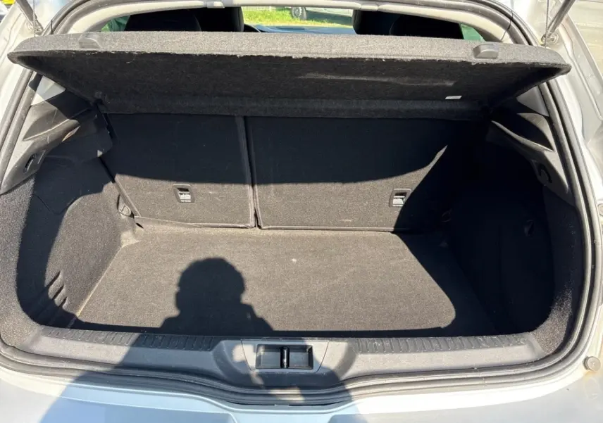 Coffre ouvert de Renault Mégane Intens Blue dCi 115 gris, vue arrière montrant l’espace de chargement vide.