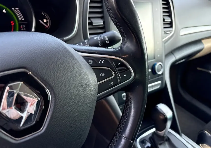 Vue intérieure rapprochée du volant cuir noir et du tableau de bord gris clair d’une Renault Mégane 2020.