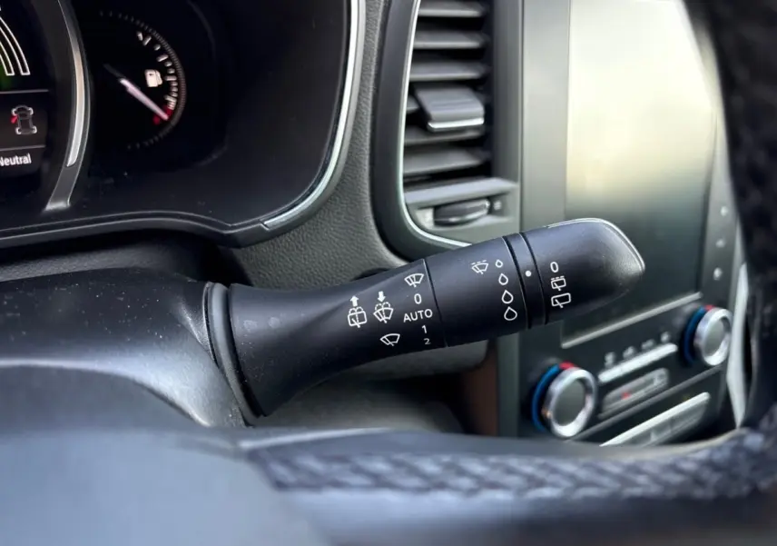 Gros plan sur la commande d’essuie-glace noire à gauche du volant dans l’habitacle de la Renault Mégane Intens 2020.