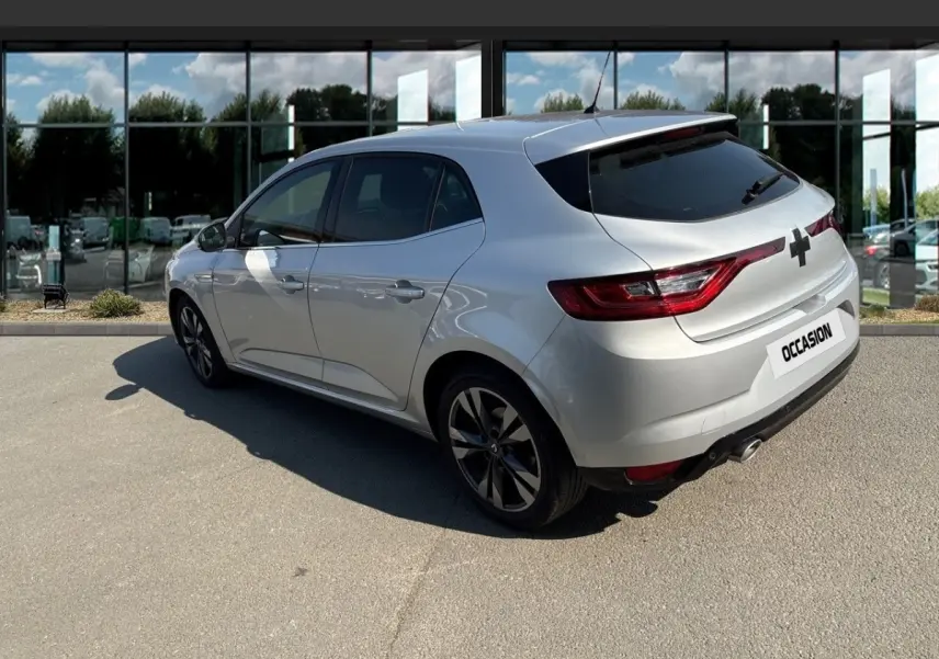 Vue 3/4 arrière droite d'une Renault Mégane Intens bleu dCi 115, couleur argentée, avec jantes noires et vitres teintées.