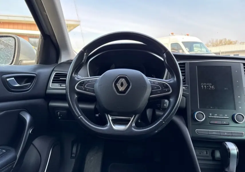 Vue intérieure centrée sur le volant cuir noir et l'écran tactile vertical du tableau de bord de la Renault Mégane 2020.
