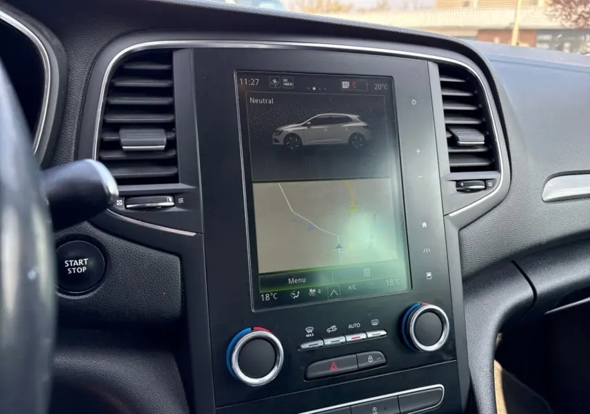 Vue rapprochée du tableau de bord noir de la Renault Mégane Intens avec écran tactile central et bouton Start/Stop visible.