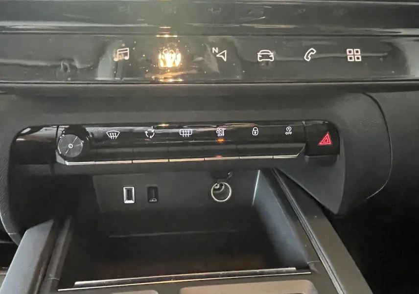 Vue rapprochée de la console centrale noire du Citroën C5 Aircross hybride 2025 avec commandes tactiles et ports USB visibles.