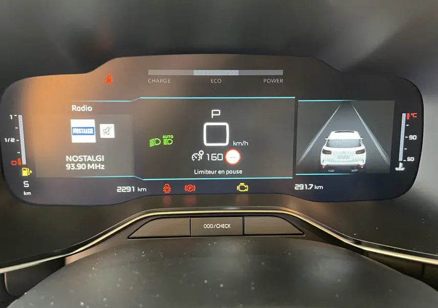 Tableau de bord numérique du Citroën C5 Aircross hybride 2025 affichant vitesse, radio et caméra de recul.