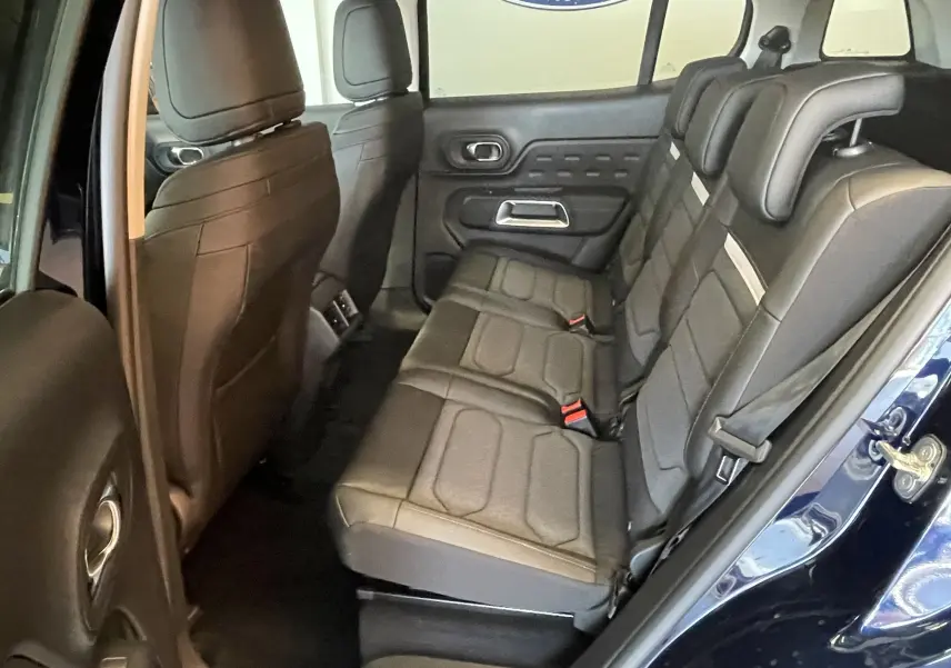 Vue intérieure côté droit des sièges arrière en tissu et TEP gris foncé du Citroën C5 Aircross hybride 2025 bleu foncé.