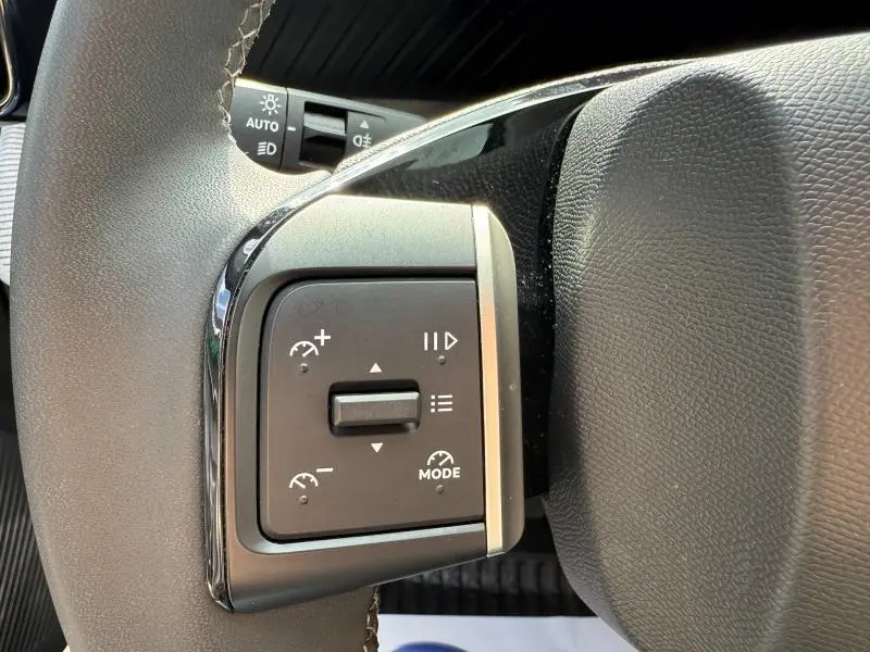Gros plan sur les commandes de régulateur de vitesse au volant noir de la Citroën C3 Gris Mercury 2025.