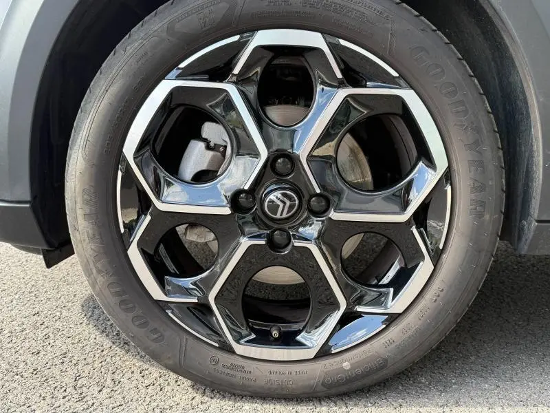 Gros plan sur la jante alu noire et chromée d'une Citroën C3 Gris Mercury avec pneu Goodyear visible.