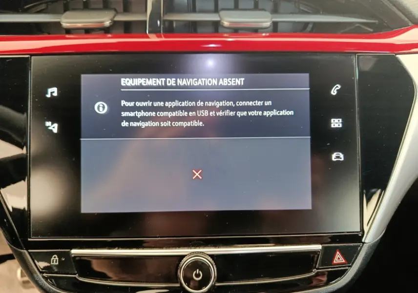 Écran tactile central de la console d’une Opel Corsa rouge 2023 affichant un message d’équipement de navigation absent.