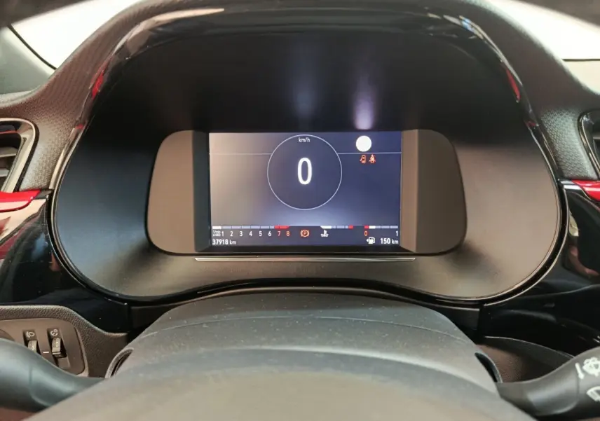 Vue rapprochée du combiné d'instruments numérique de l'Opel Corsa rouge 2023, affichant la vitesse à 0 km/h.