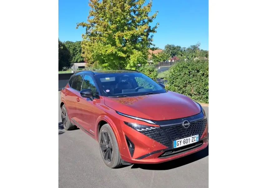 Nissan Qashqai 2024 rouge foncé en 3/4 avant droit, avec calandre noire et jantes noires distinctives.