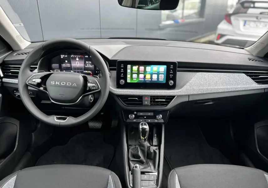 Vue intérieure frontale du tableau de bord du Skoda Kamiq 2025 avec écran tactile Apple Car Play et volant multifonctions.
