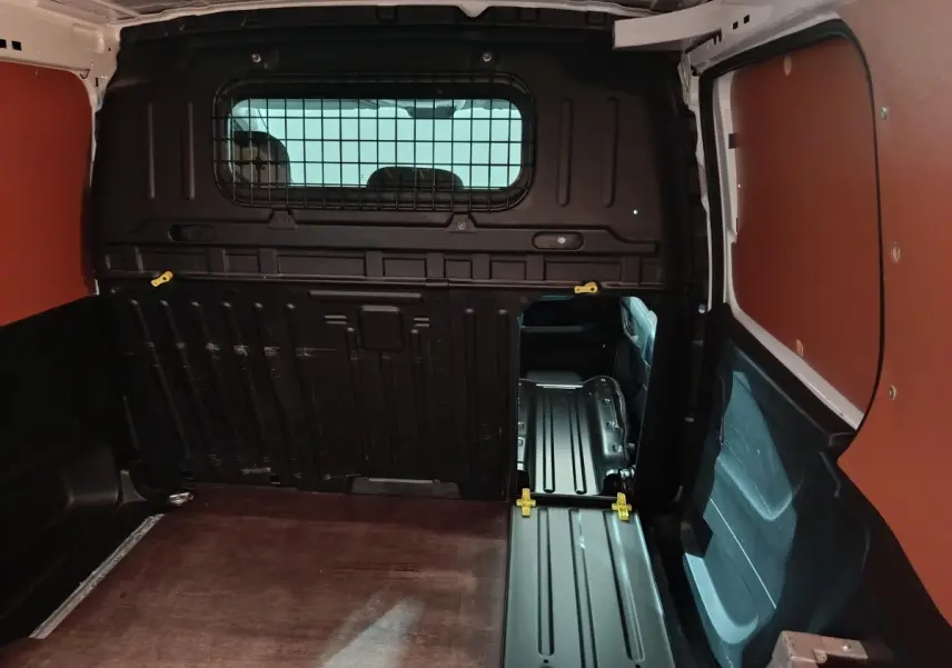Intérieur du coffre du Citroën Berlingo blanc 2021, cloison pleine noire avec ouverture vers l'avant du véhicule.