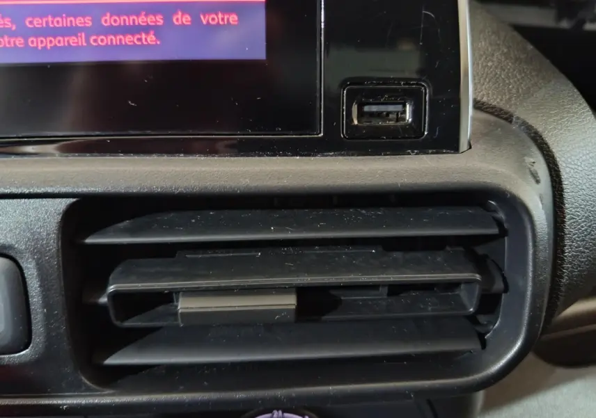 Gros plan sur la sortie d'air et port USB du tableau de bord du Citroën Berlingo blanc, version 2021.