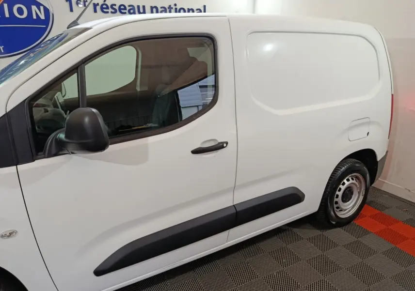 Vue latérale côté droit d'un utilitaire Citroën Berlingo blanc avec porte latérale pleine et jantes acier.