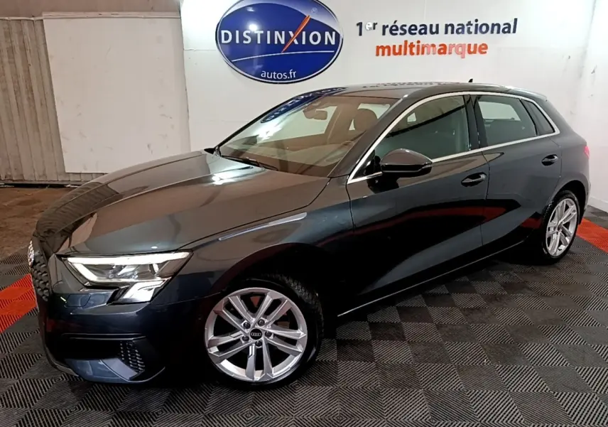 Audi A3 35 TFSI gris foncé vue 3/4 avant droit, avec jantes alliage et phares LED allumés.
