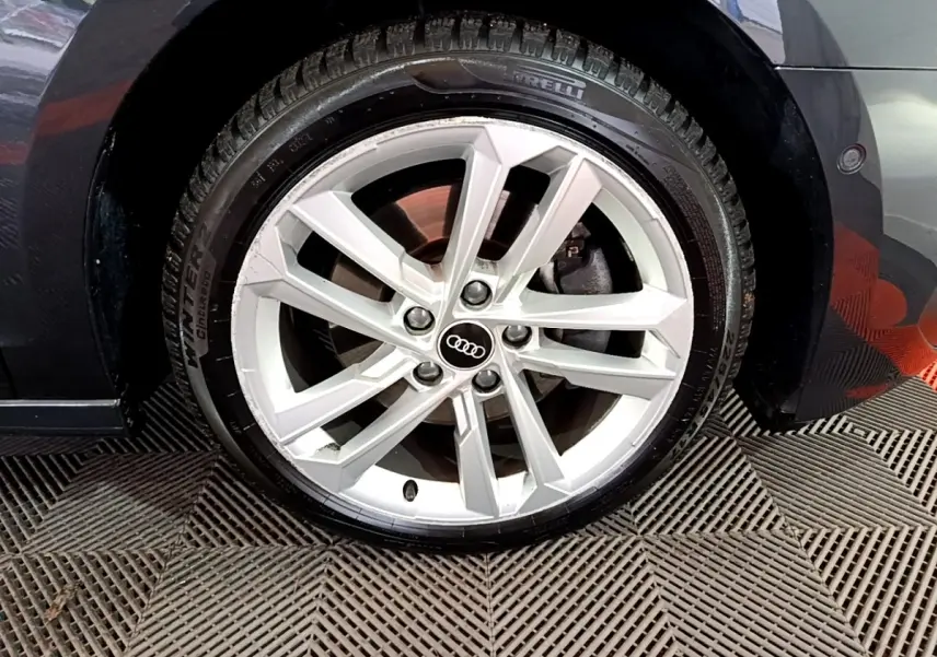 Gros plan sur la roue avant gauche gris foncé d’une Audi A3 35 TFSI 150 MHEV avec jante alliage à 5 doubles branches.
