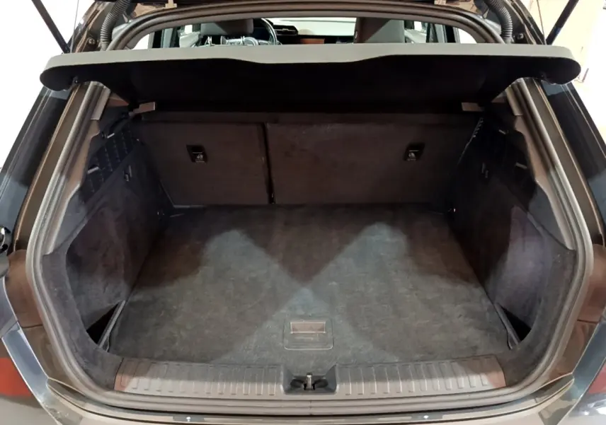 Coffre ouvert vu de l'arrière d'une Audi A3 gris foncé, montrant un espace de chargement propre et spacieux.