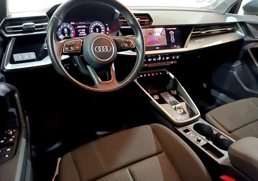 Vue intérieure de l'Audi A3 35 TFSI 2021, tableau de bord et volant cuir noir avec écran tactile et affichage numérique.