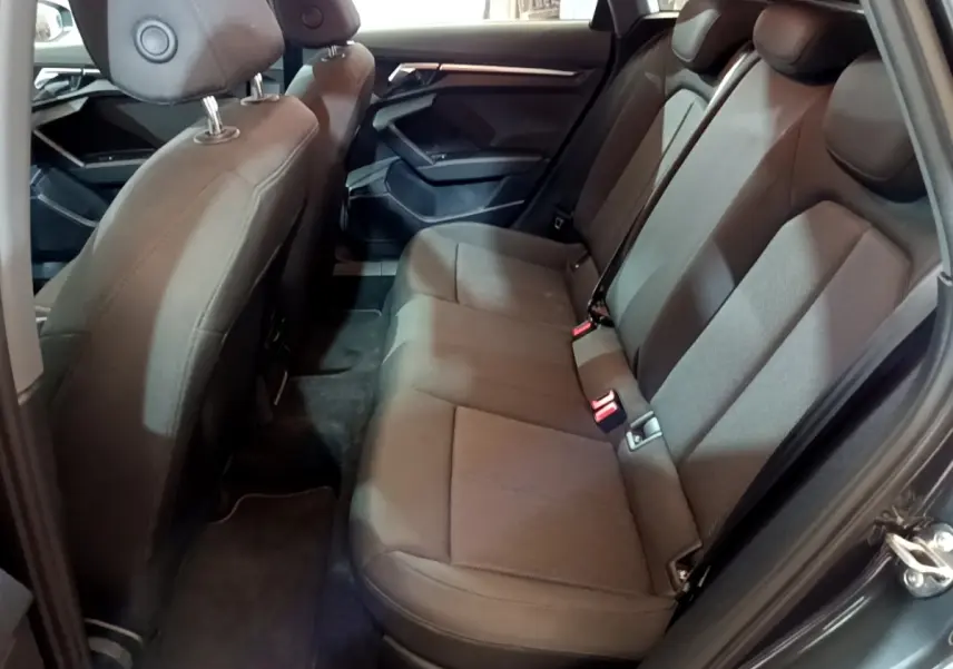 Vue intérieure côté droit des sièges arrière en tissu gris foncé de l'Audi A3 35 TFSI 2021 avec portes ouvertes.