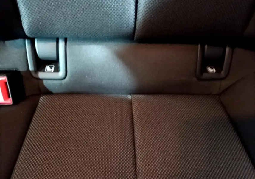Gros plan sur la banquette arrière noire de l'Audi A3 35 TFSI, montrant les attaches ISOFIX et la ceinture de sécurité.