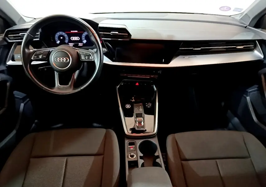 Vue intérieure avant de l'Audi A3 35 TFSI 2021, tableau de bord moderne avec volant cuir et console centrale noire brillante.
