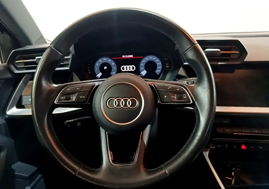 Vue centrée sur le volant cuir noir et le tableau de bord numérique d'une Audi A3 Business Line 2021.