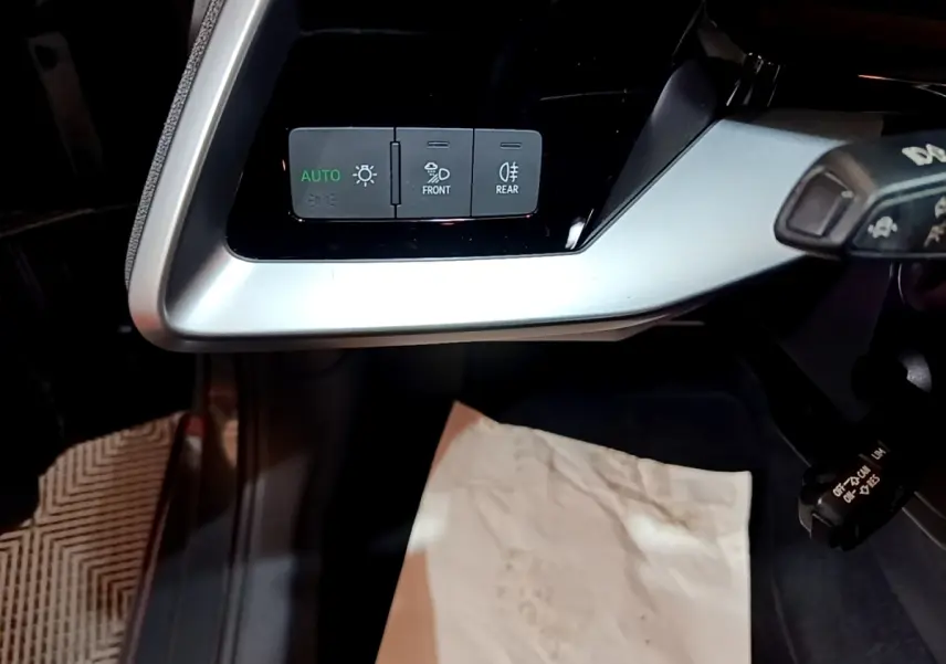 Vue rapprochée du panneau de commandes d’éclairage à gauche du volant dans l’Audi A3 gris foncé 2021.