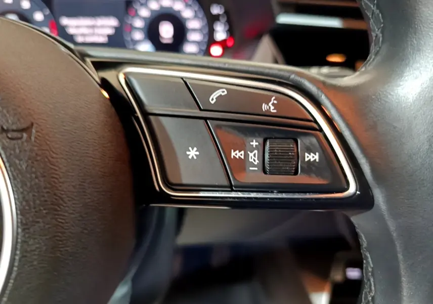 Gros plan sur les commandes multifonctions côté droit du volant cuir noir d’un Audi A3 35 TFSI 2021.