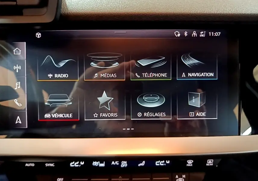Écran tactile central de l'Audi A3 35 TFSI 2021 affichant les menus multimédias, navigation et réglages, intérieur noir.