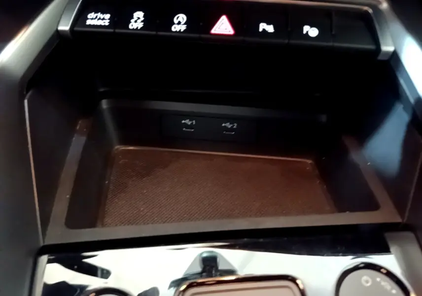 Vue rapprochée de la console centrale noire de l’Audi A3 35 TFSI avec boutons de contrôle et ports USB visibles.