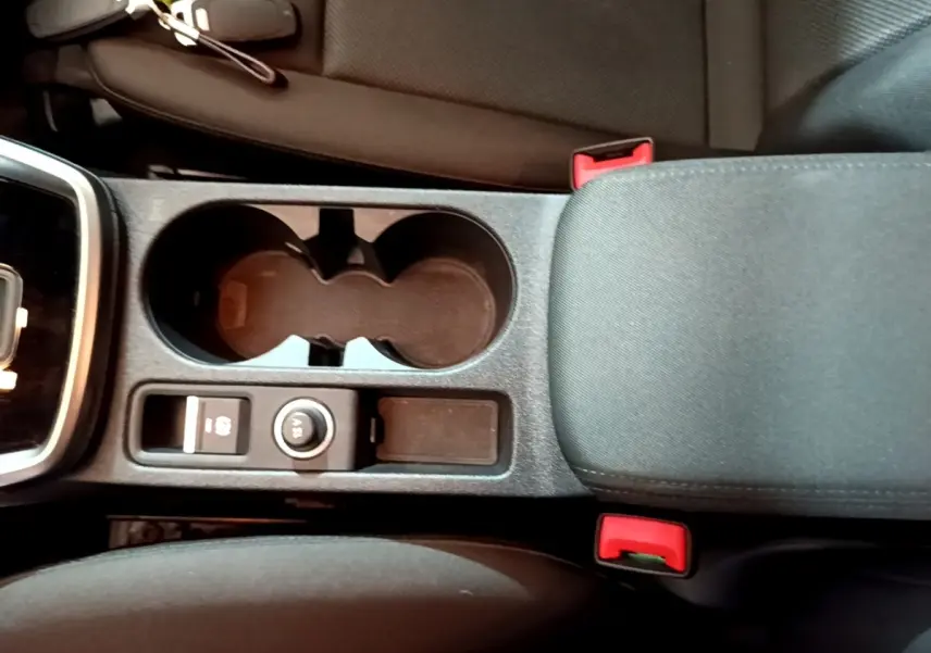 Vue plongeante sur la console centrale noire de l'Audi A3 35 TFSI 2021 avec porte-gobelets et accoudoir tissu.