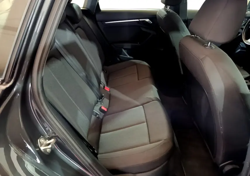 Vue intérieure côté gauche montrant la banquette arrière en tissu gris foncé de l'Audi A3 35 TFSI 2021.