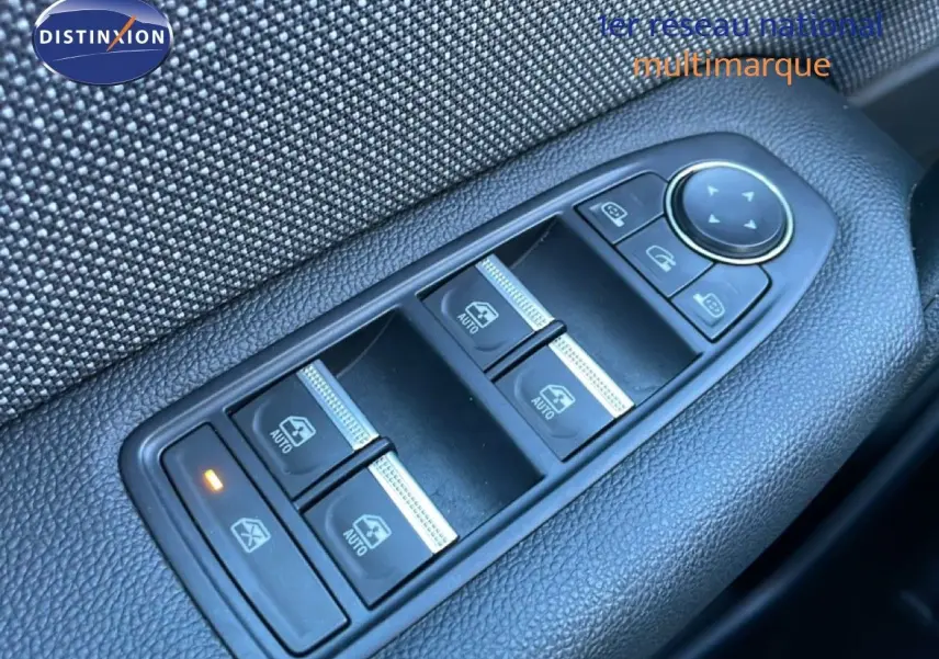 Gros plan sur les commandes des vitres électriques côté conducteur du Renault Captur rouge Désir Métal avec toit noir.