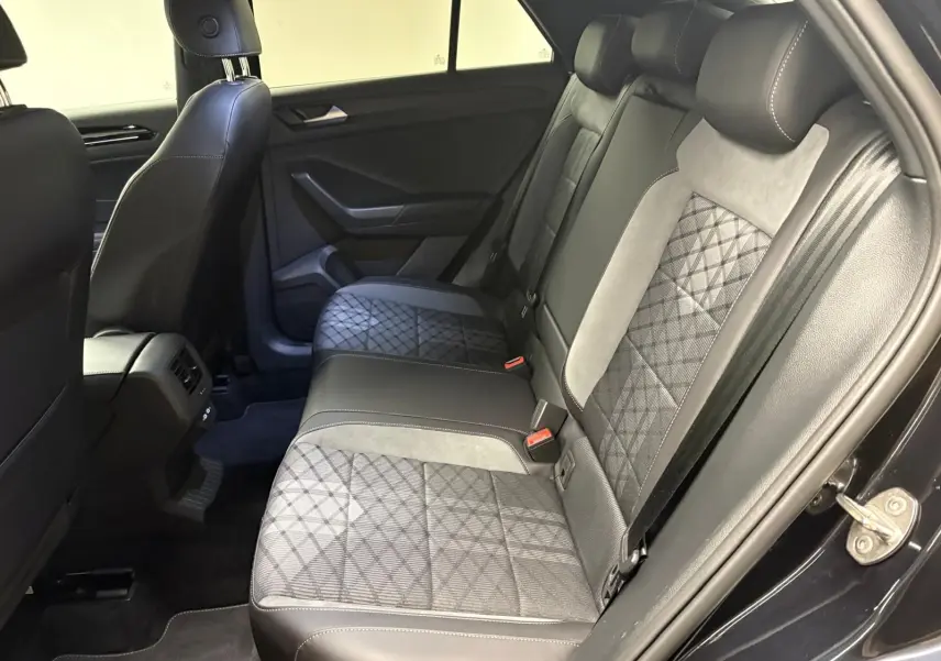Vue intérieure côté droit des sièges arrière en tissu et cuir noir avec surpiqûres blanches du Volkswagen T-Roc 2025.