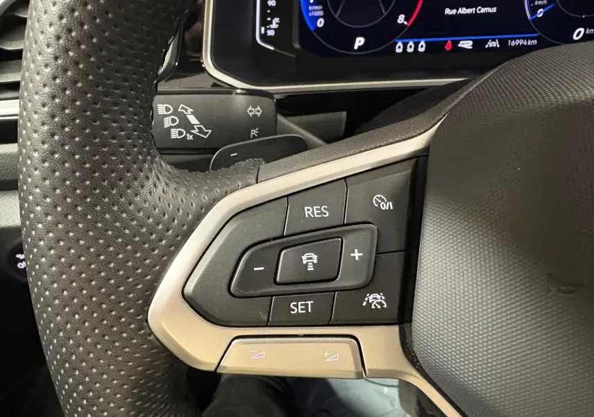 Gros plan sur le volant perforé du Volkswagen T-Roc 1.5 TSI 150 DSG7 R-Line Edition avec commandes de régulateur de vitesse.