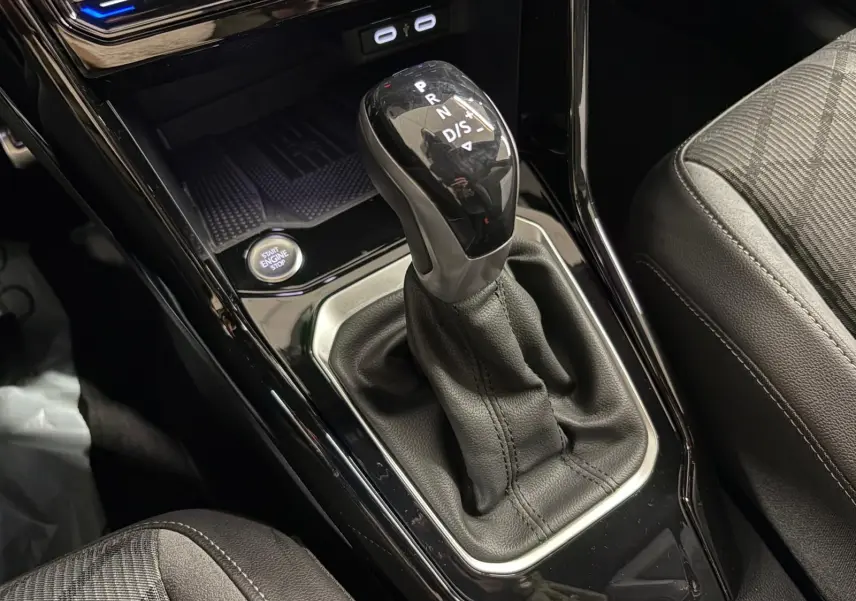 Gros plan sur le levier de vitesse automatique noir brillant du Volkswagen T-Roc 1.5 TSI R-Line, avec bouton start/stop visible.