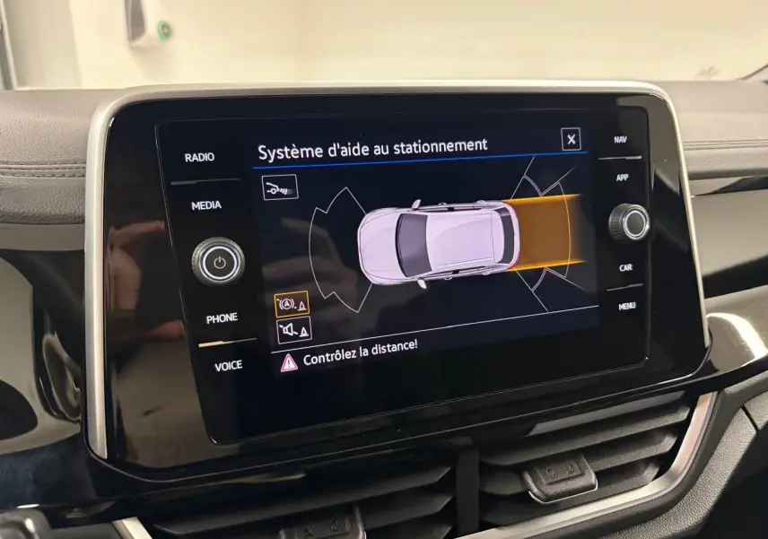 Écran central du système d'aide au stationnement du Volkswagen T-Roc 2025, affichage en vue de dessus du véhicule.