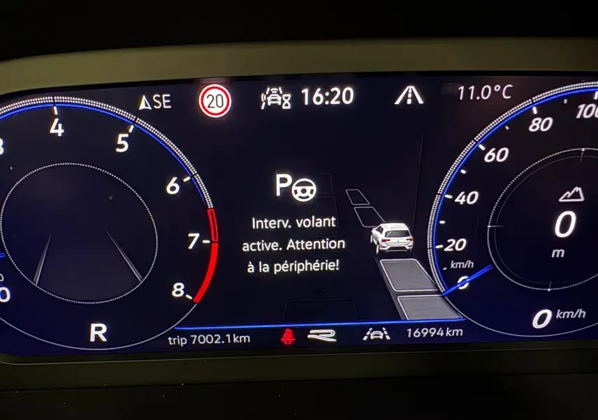 Tableau de bord numérique du Volkswagen T-Roc 2025 affichant une alerte d'assistance au volant, vitesse et température.