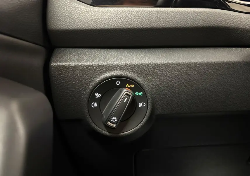 Gros plan sur le bouton de commande des phares du Volkswagen T-Roc 1.5 TSI 150 DSG7 R-Line Edition, intérieur noir.