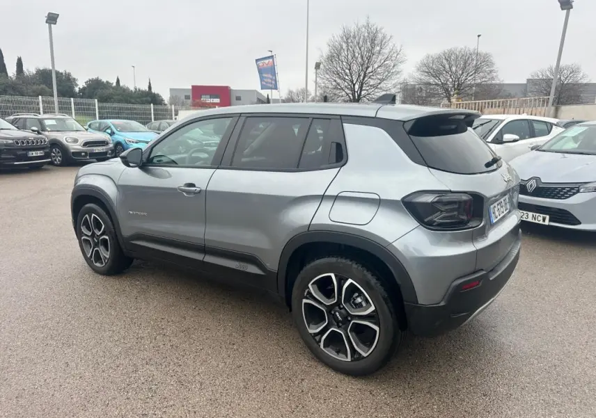 Jeep Avenger gris foncé vu en 3/4 arrière droit, avec jantes alliage 18 pouces et vitres teintées.