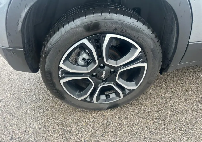 Gros plan sur la roue avant gauche du Jeep Avenger gris foncé avec jante alliage 18 pouces au design moderne.