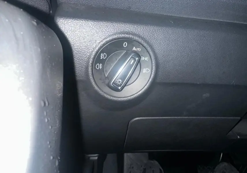 Gros plan sur le bouton de réglage des phares dans l'habitacle noir du Jeep Avenger 2025.