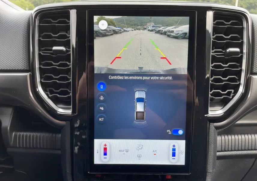 Vue rapprochée de l’écran tactile central du Ford Ranger gris carbone, affichant la caméra de recul et l’aide au stationnement.