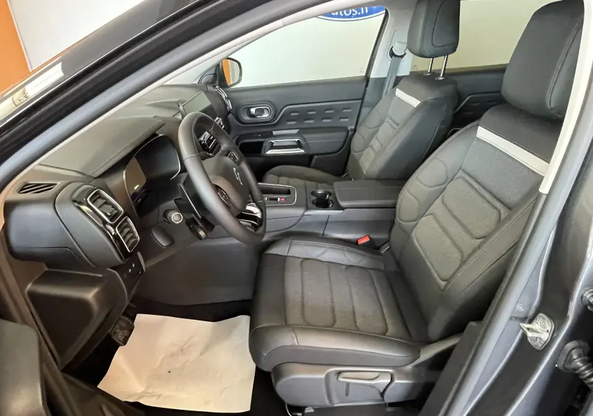 Vue intérieure côté conducteur du Citroën C5 Aircross hybride gris platinium, sièges tissu/TEP et volant cuir croûte.