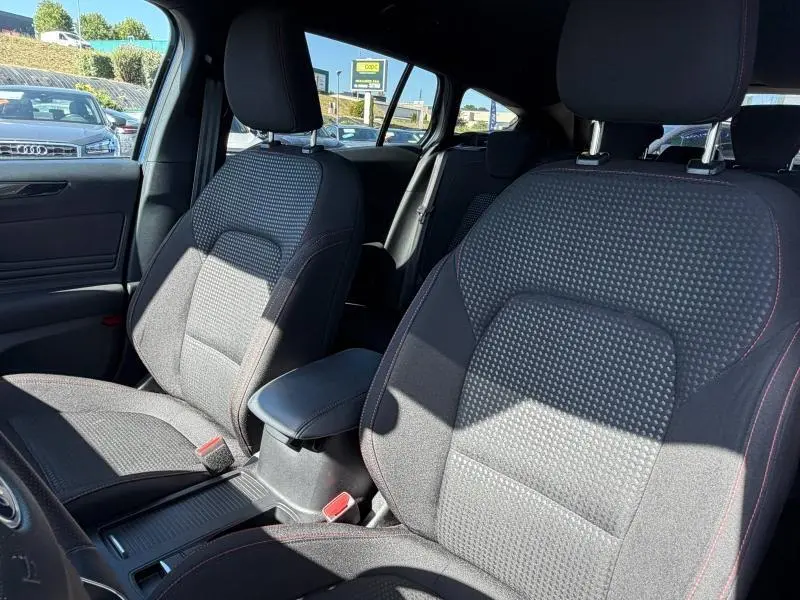 Vue intérieure sur les sièges avant en tissu noir avec surpiqûres rouges de la Ford Focus SW 2023.
