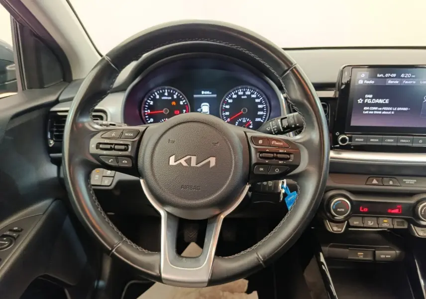 Vue intérieure centrée sur le volant cuir noir et le tableau de bord digital du Kia Stonic 2023.